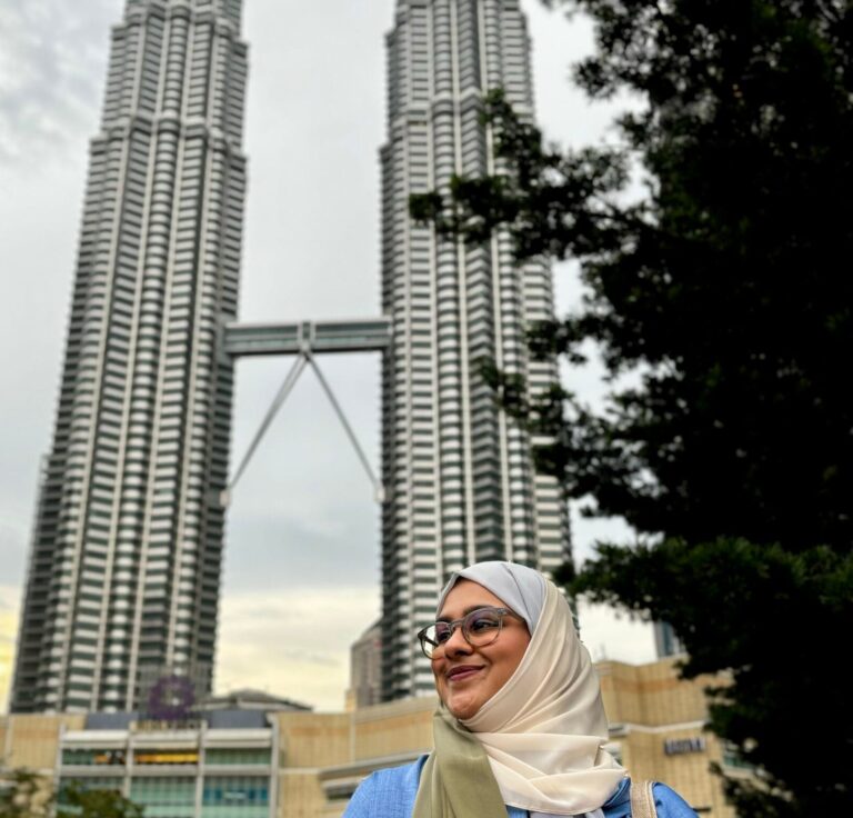 Image of a girl standing infront of Petronas tower in Kuala Lumpur